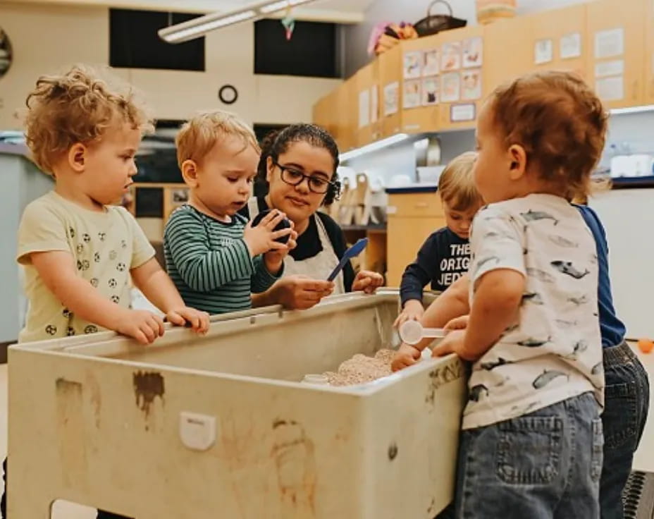 a group of kids looking at a white box