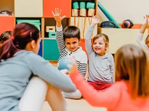 a group of children raising their hands