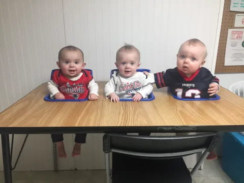 a group of babies sitting at a table