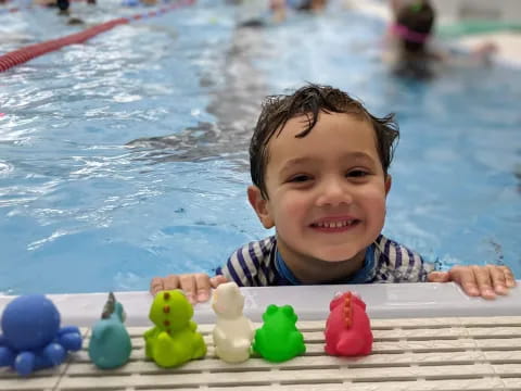 a boy in a pool with balls