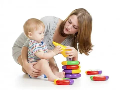 a person and a baby playing with toys