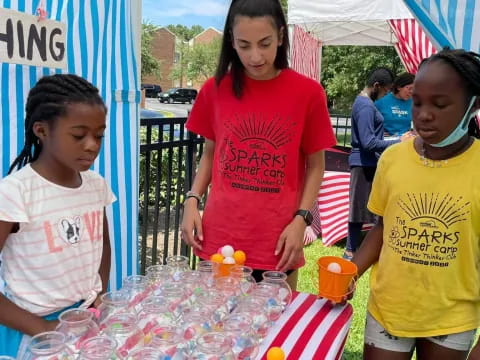 a group of people standing around a table with food on it