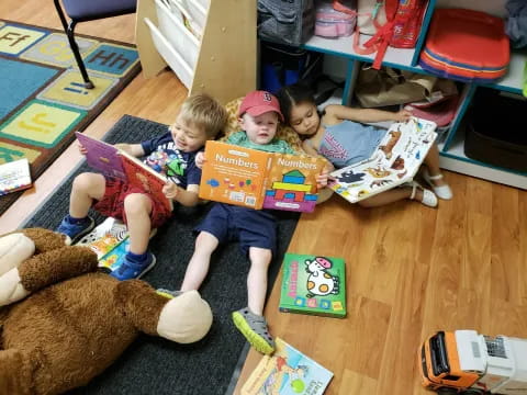 children sitting on the floor with toys