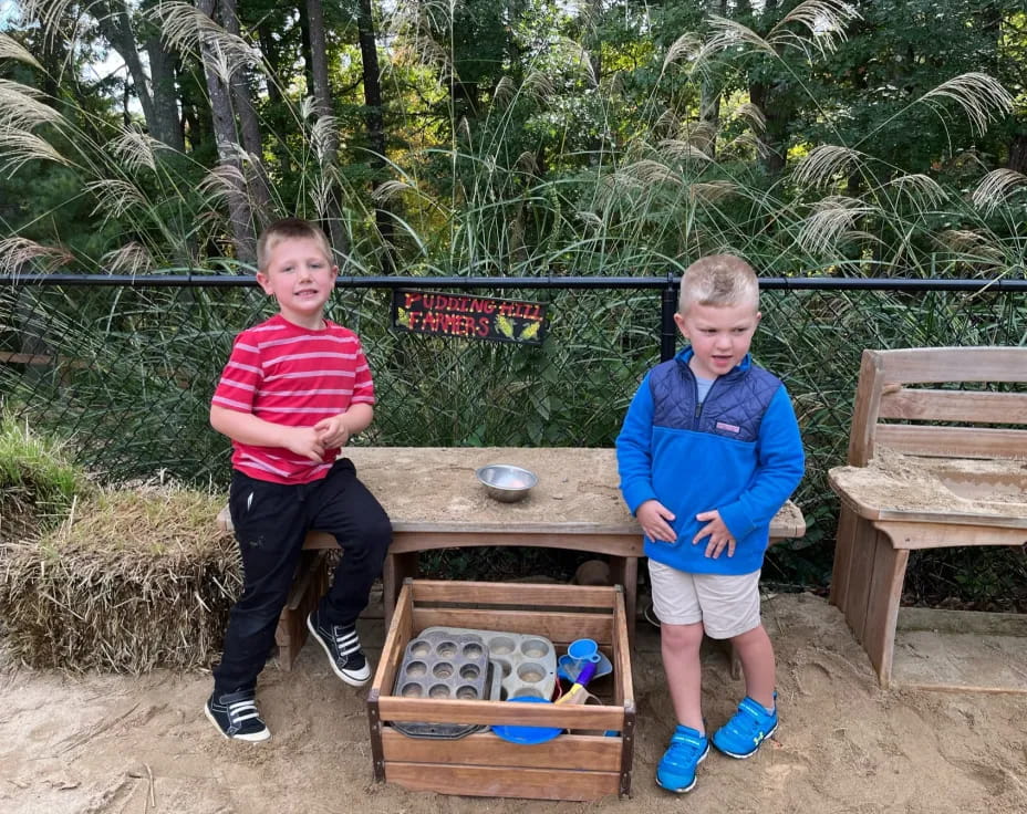 two boys standing next to a table