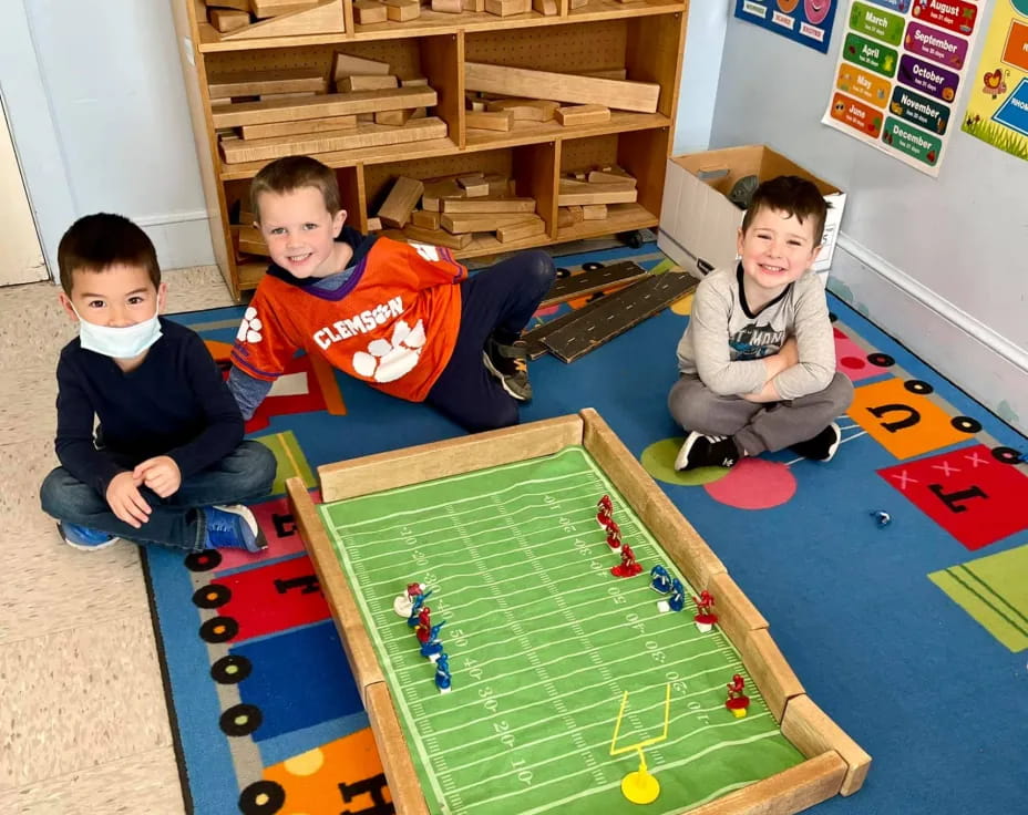 a group of kids sitting on the floor playing a board game