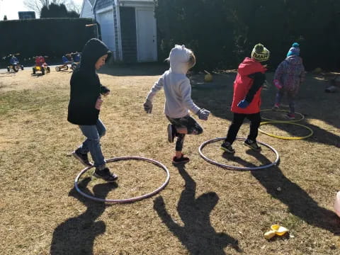 a group of children playing with hoops on a dirt field