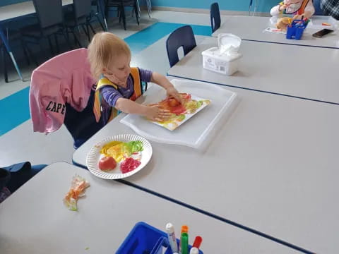 a child sitting at a table eating food