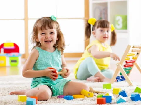 a couple of young girls playing with toys on the floor