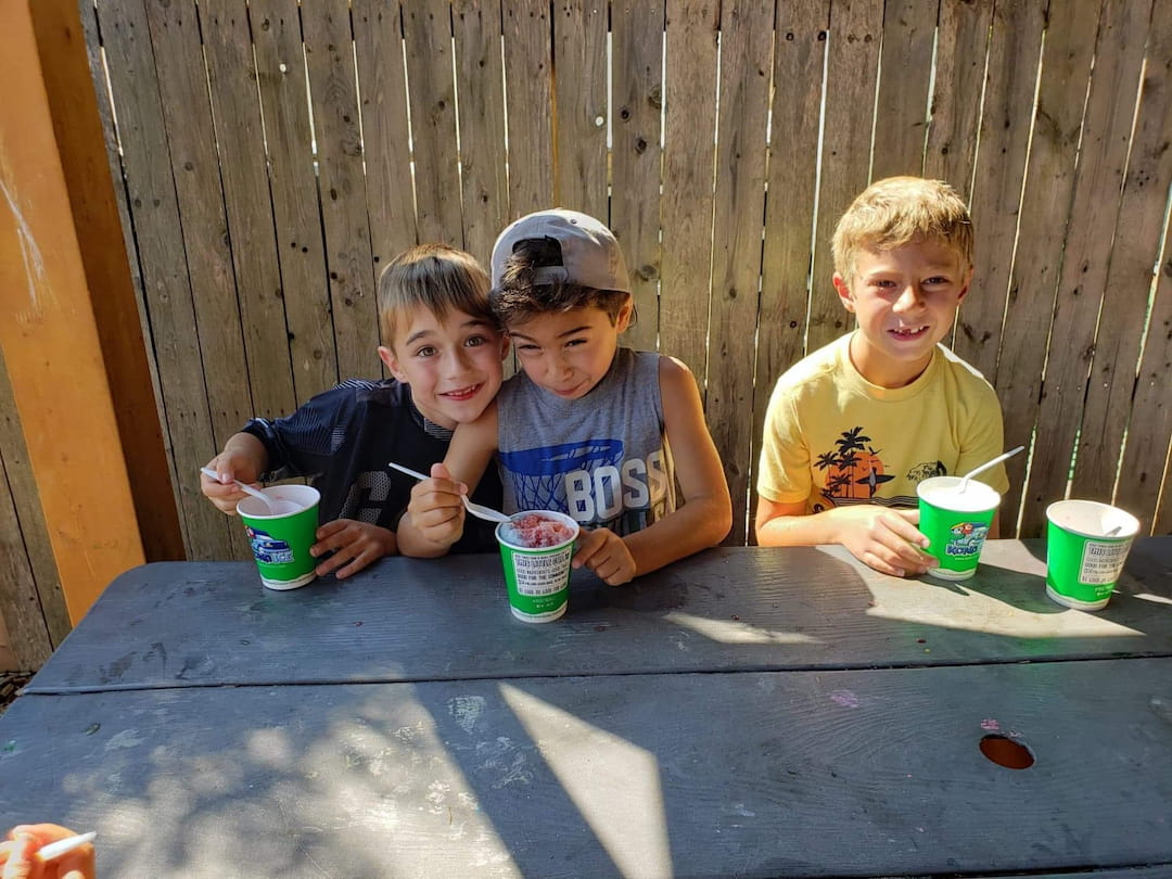 a group of boys sitting at a table with green cups