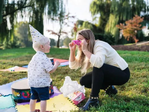 a person and a child playing with toys in a yard