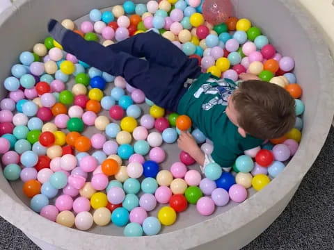 a child playing in a ball pit