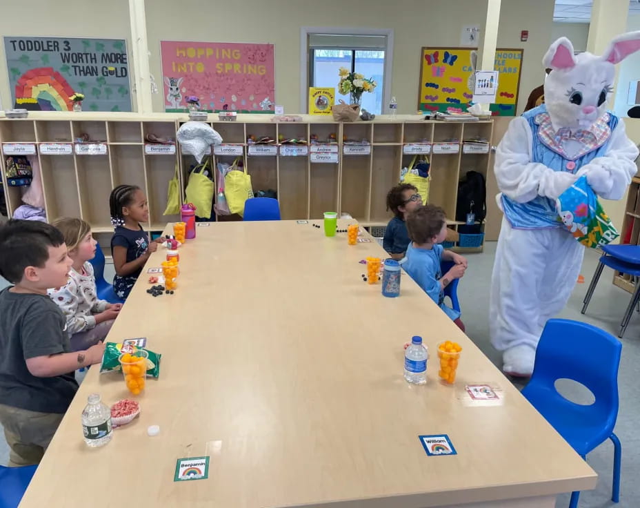 a group of children sitting at a table with toys