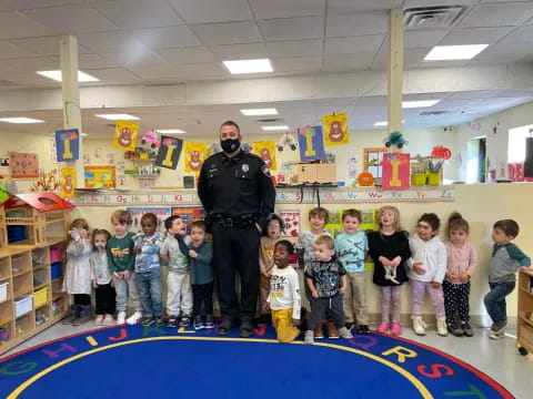 a person standing in front of a group of children in a room