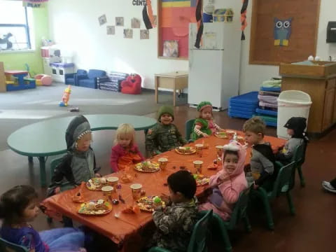 a group of children sitting around a table eating