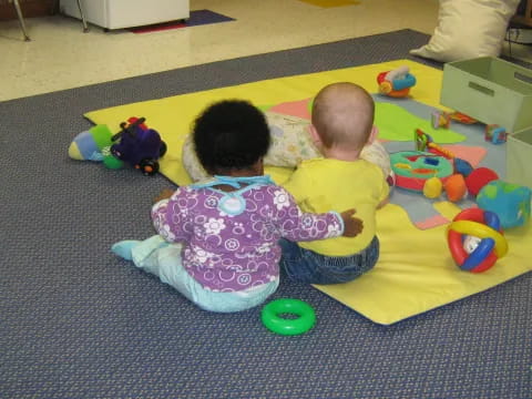 two babies sitting on the floor