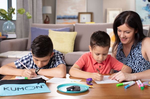 a person and two children sitting at a table