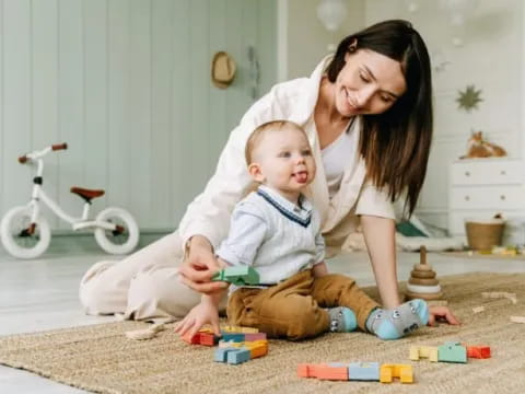 a person and a baby playing with toys