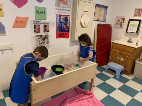 a person and a girl playing with toys in a room with posters on the wall