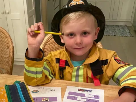 a boy wearing a hat and holding a pencil