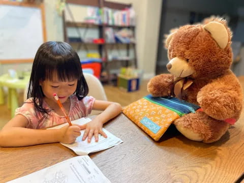 a young girl writing on a book