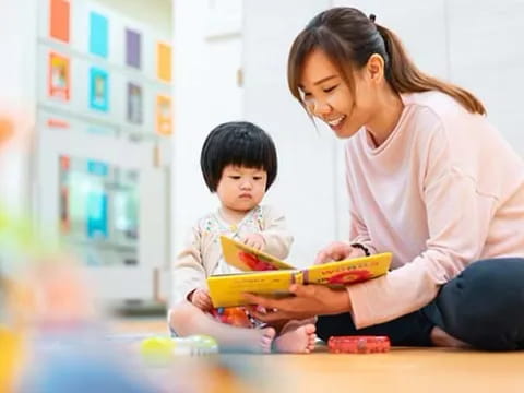 a person and a child looking at a book