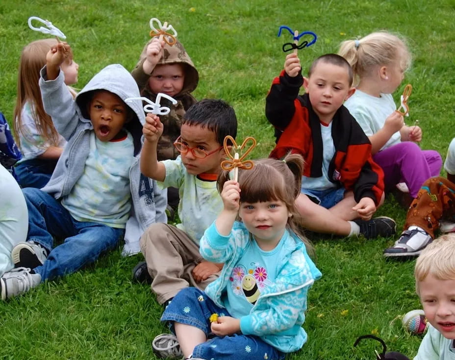 a group of children sitting on the grass