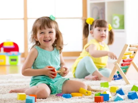 a couple of young girls playing with toys on the floor