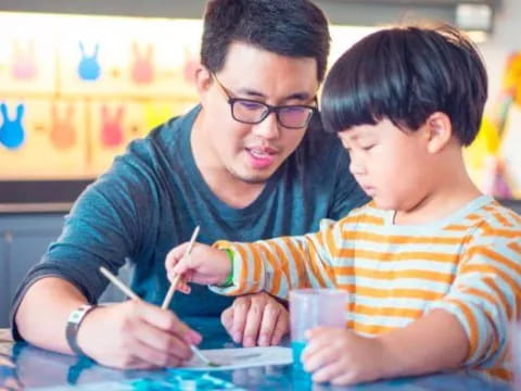 a person and a boy sitting at a table