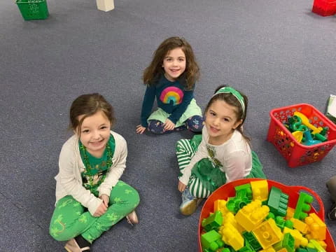 a group of girls sitting on the ground with flowers