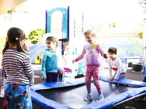 a group of children standing on a trampoline