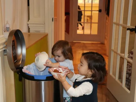 a couple of kids eating from a bowl