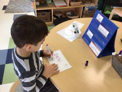 a child writing on a piece of paper