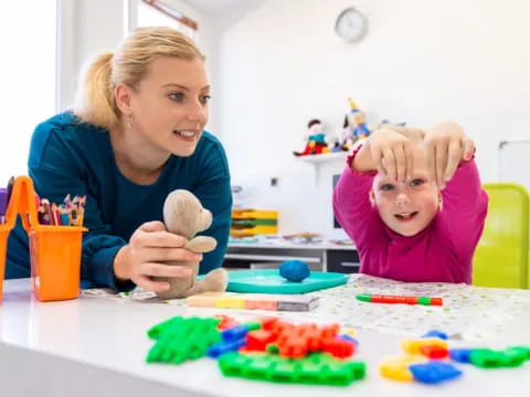 a person and a child playing with toys on a table