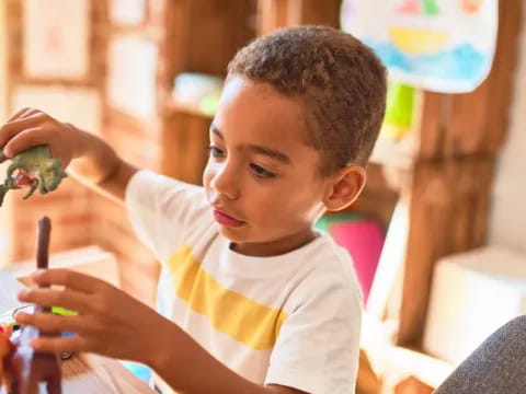 a young boy holding a pen