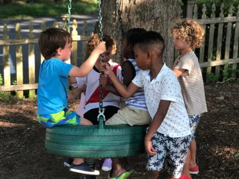 a group of children playing on a swing