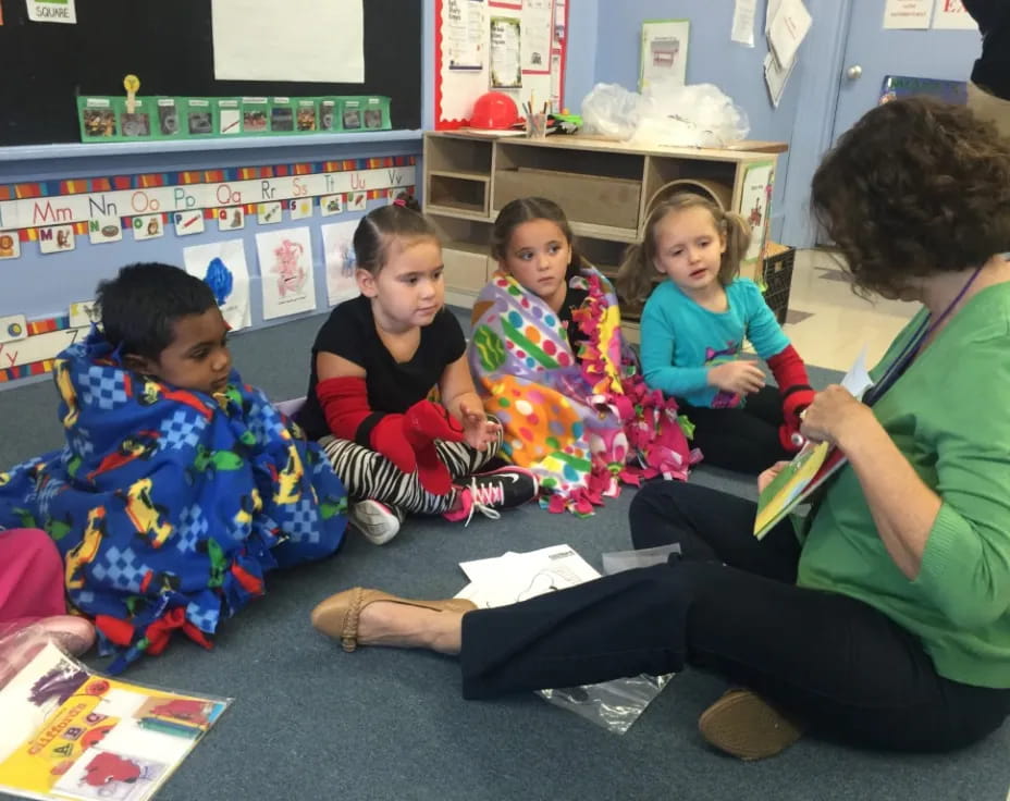 a person and several children sitting on the floor