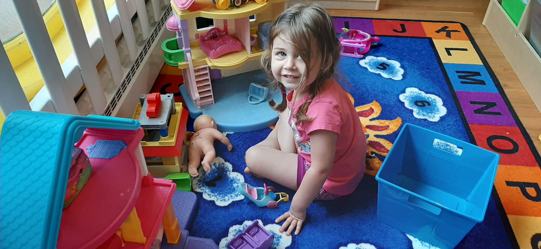 a girl and a baby playing on a blue and yellow play set