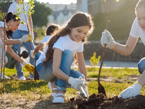 a group of girls planting a tree