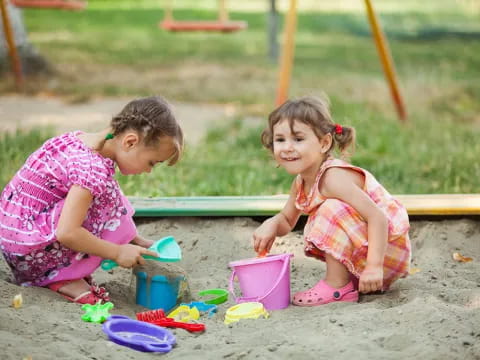 a couple of girls playing in the sand