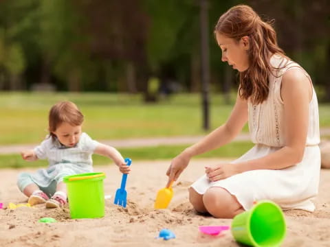 a person and a child playing in the sand