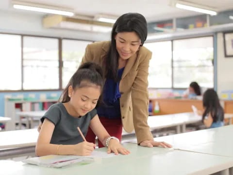 a woman and a child writing on a piece of paper