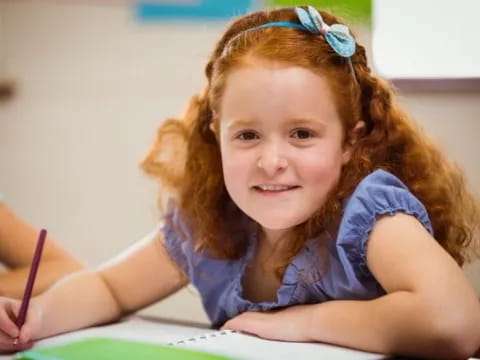 a young girl sitting at a desk