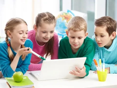 a group of children looking at a laptop