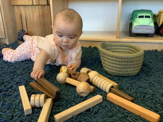 a baby playing with wooden toys