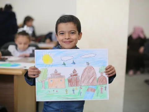 a boy holding a drawing