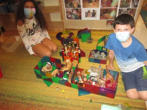 a boy and girl playing with a toy building