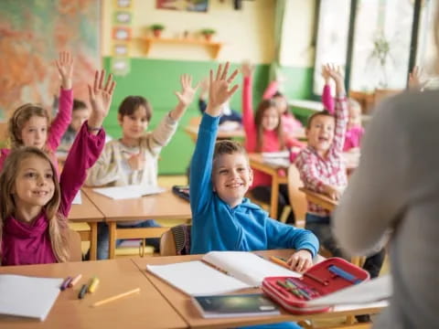 a group of children raising their hands