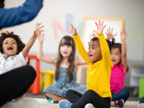 a group of children raising their hands