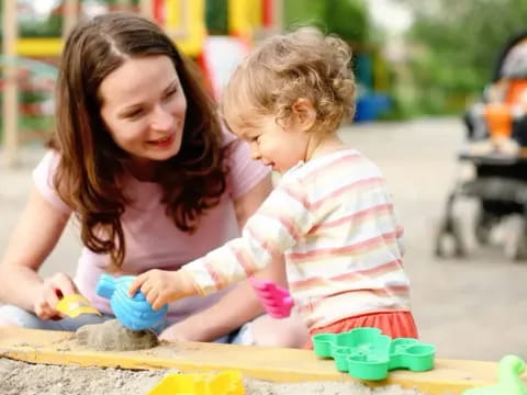 a person and a child playing with sand