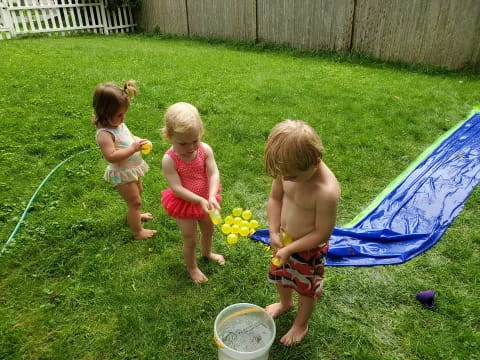 a group of children playing in the grass